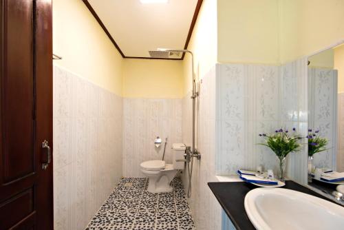 a bathroom with a sink and a toilet at Annecy Hotel in Vang Vieng