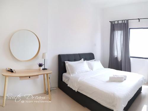 a bedroom with a bed with a mirror and a table at Suite Dream@Icon Residence in Kuala Terengganu