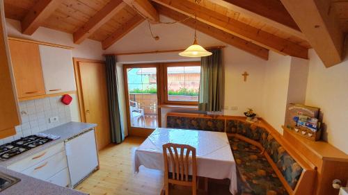 a kitchen with a table and a kitchen with a window at Oberpapping in San Candido