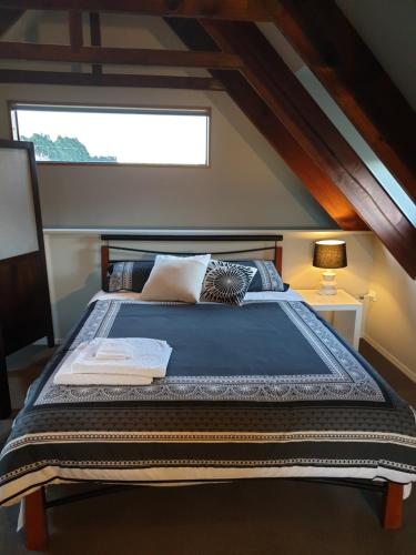 ein großes Bett in einem Zimmer mit Fenster in der Unterkunft Accommodation at Lakeside in Oamaru