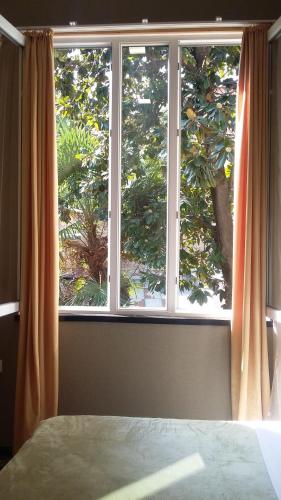 a bedroom with a large window with orange curtains at Joniskera in Tbilisi City