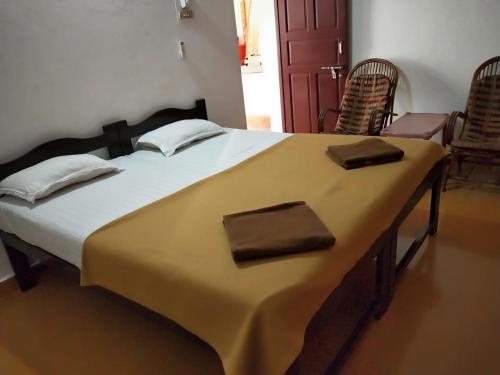 a large bed in a room with two chairs at Alexmarie Guest house 5 min to candolim Beach in Aguada