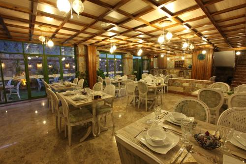 a restaurant with white tables and chairs and windows at Celsus Boutique Hotel in Selçuk