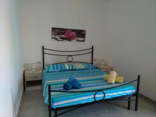 Un dormitorio con una cama con rayas azules y azules. en Budoni Apartments, en Budoni