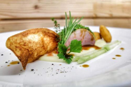 a plate of food with meat and vegetables on it at Hotel Tyrol Plose in Bressanone