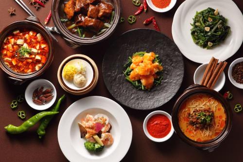 a table with plates of food and bowls of food at Kobe Meriken Park Oriental Hotel in Kobe