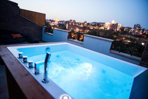 eine Whirlpool-Badewanne auf dem Dach eines Gebäudes in der Unterkunft Hotel City Lights - Tbilisi in Tbilisi City