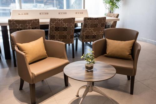 a dining room with two chairs and a table at Noku Osaka in Osaka