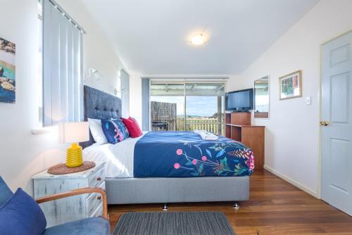 um quarto com uma cama king-size e uma televisão em Surfside Ocean Beach Denmark Holiday Accommodation em Denmark