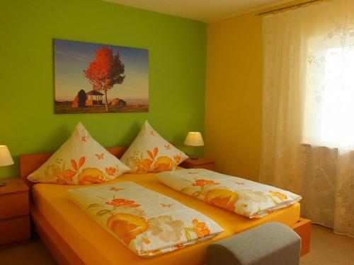 ein Schlafzimmer mit einem Bett mit grünen Wänden in der Unterkunft Ferienwohnung Schnee in Bischoffingen
