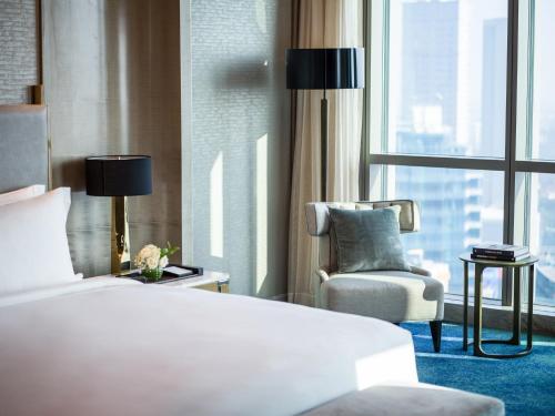 a hotel room with a bed and a chair and a window at InterContinental Hotels Jakarta Pondok Indah by IHG in Jakarta