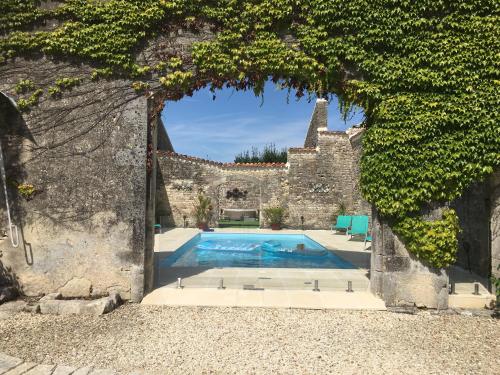 a swimming pool in the middle of a stone wall with a doorway at 1854 Chassors in Chassors