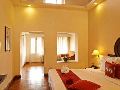 a bedroom with a bed with a cat laying on it at Club Mahindra Derby Green, Ooty in Ooty