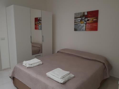 una camera da letto con un letto e due asciugamani di Janara - Teatro Romano a Benevento