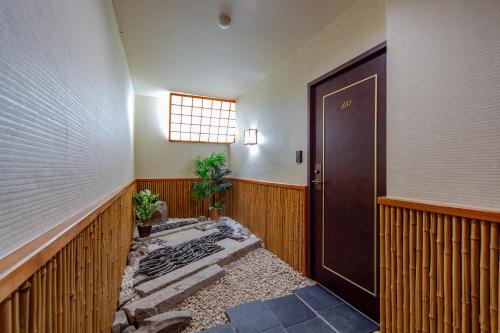un pasillo con puerta y una habitación con suelo en Obama Onsen Hamakan Hotel, en Unzen