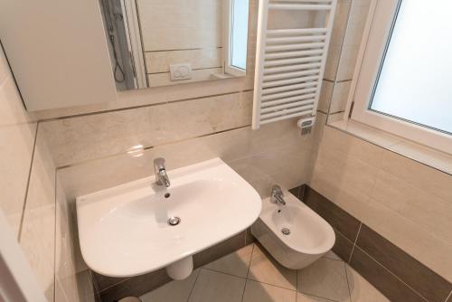 a bathroom with a white sink and a mirror at Prestige Apartments by Quokka 360 - spacious flats with terraces in Lugano