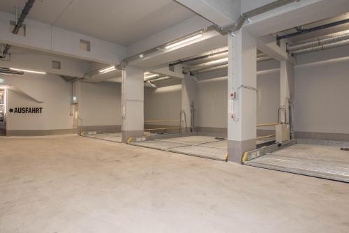 an empty garage with concrete floors and white walls at Innspire Hotel in Munich