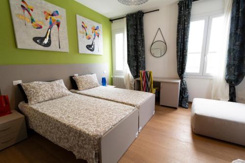 1 dormitorio con 2 camas y paredes verdes en LA CASA QUADRA, en Fontanelle