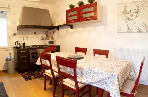 a kitchen with a table with chairs and a stove at LA CASA QUADRA in Fontanelle