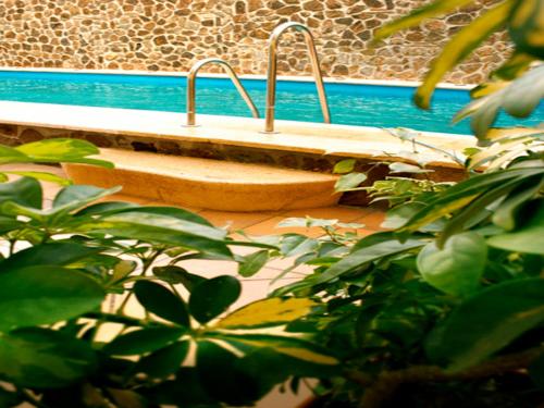 un banco de madera sentado junto a una piscina en Oh Nice Ulises Ceuta en Ceuta