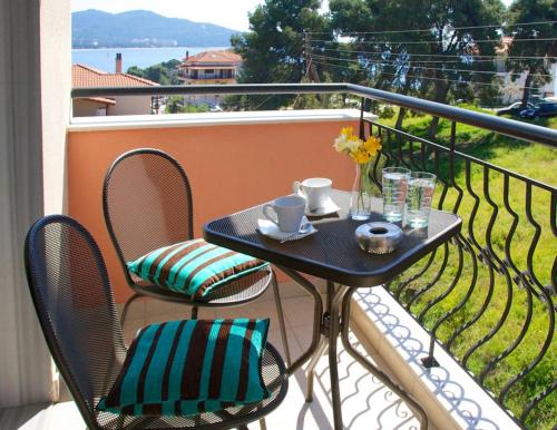 d'une table et de chaises noires sur le balcon. dans l'établissement Kaplanis House, à Neos Marmaras