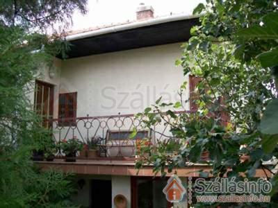 a house with a balcony with potted plants on it at Kanyar Vendégház in Pécs