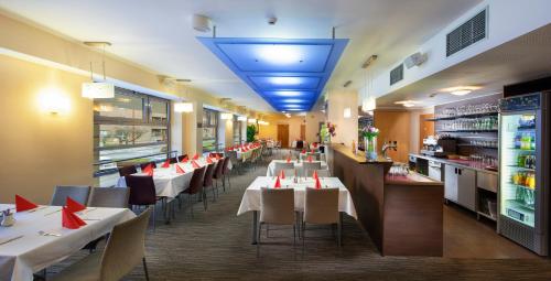 a restaurant with tables and chairs in it at Academic Hotel & Congress Centre in Roztoky