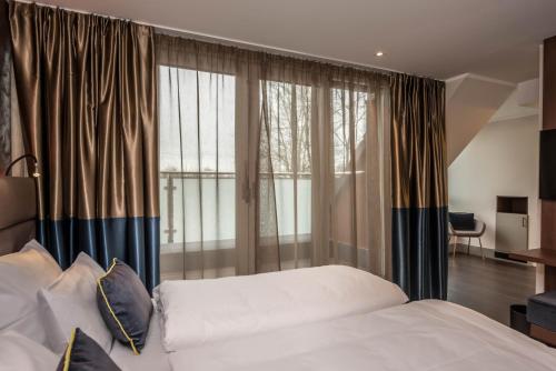 a bedroom with a bed and a large window at Innspire Hotel in Munich