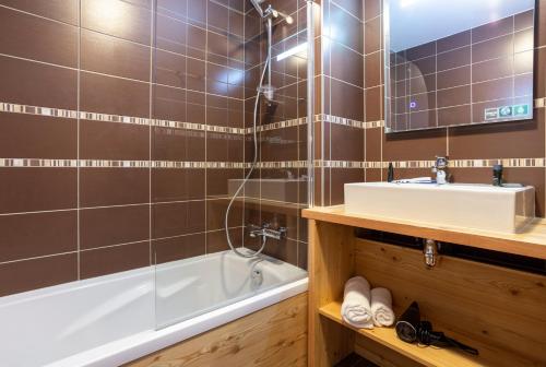 a bathroom with a tub and a sink and a bath tubermottermott at Résidence Club MMV L'Altaviva in Tignes