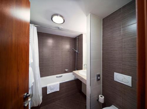 a bathroom with a shower, toilet and sink at Academic Hotel & Congress Centre in Roztoky
