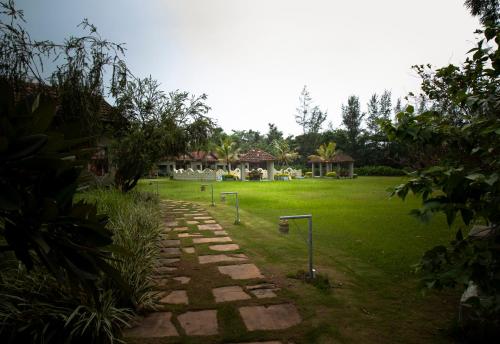 a garden with a stone path in front of a house at Breathing Earth - Rooms and Pool in Kolkata