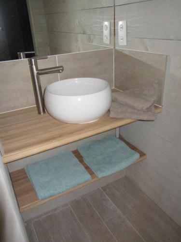 uma casa de banho com um lavatório numa prateleira de madeira com toalhas em Villa Batelo em Six-Fours-les-Plages