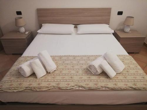 - une chambre avec un lit doté de 3 oreillers et de serviettes dans l'établissement Remarè Casa vacanze, à Gallipoli