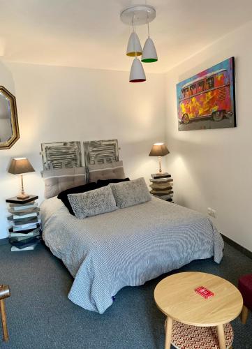 ein Schlafzimmer mit einem Bett, zwei Lampen und einem Tisch in der Unterkunft Appartement des Petits Princes in Valençay