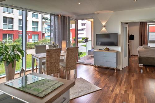 a living room with a dining table and a television at "myHarbourfront", luxuriöses Wohnen an der Hafenmole in Rostock