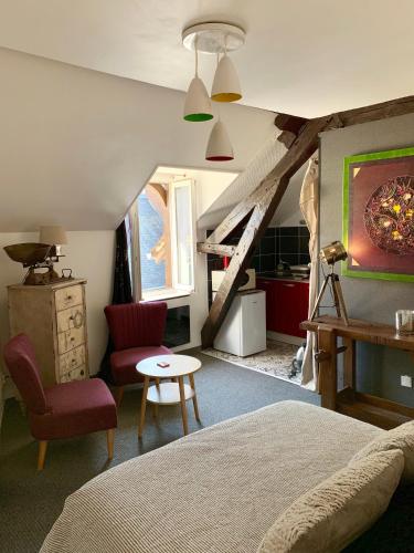 une chambre avec un lit, une chaise et une table dans l'établissement Appartement des Petits Princes, à Valençay