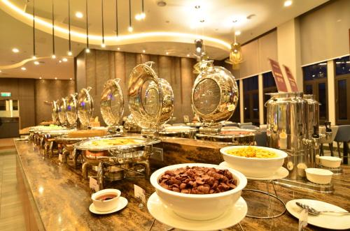 a buffet with bowls of food on a counter at Mercure Selangor Selayang in Batu Caves