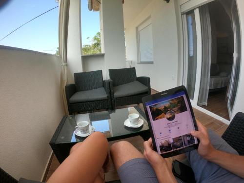 une personne prend une photo d'un salon avec une tablette dans l'établissement Apartmani Zekic, à Lopar