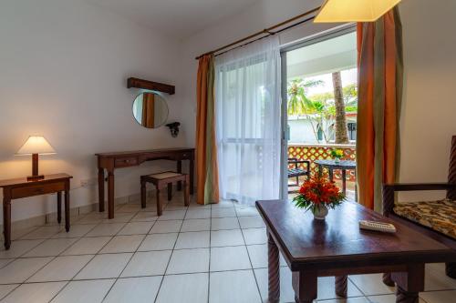 a living room with a couch and a table at Diani Sea Lodge - All Inclusive in Diani Beach