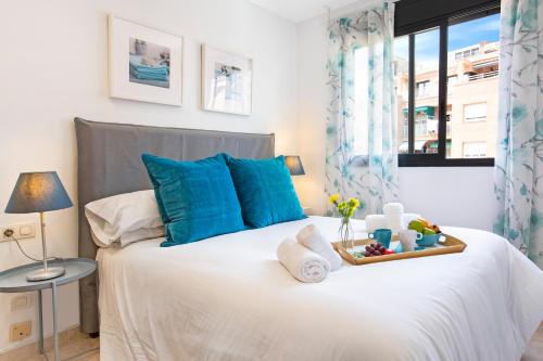 - une chambre avec un lit blanc et des oreillers bleus dans l'établissement Stay U-nique Apartments Ricart, à Barcelone
