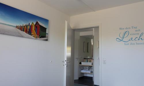 a bathroom with a painting on the wall at Apartments im Sössaarep's Hüs in Nebel