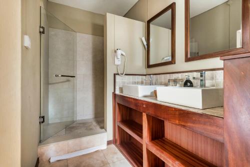 uma casa de banho com 2 lavatórios e um chuveiro em Villa Vakoa - Tranquil Villa With Lush Gardens em Pointe d'Esny