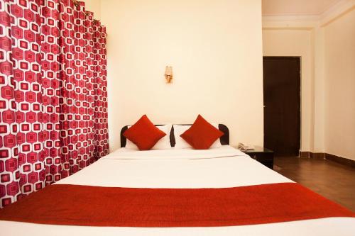 a bedroom with a large bed with red pillows at Hotel The Holy Birth in Lumbini