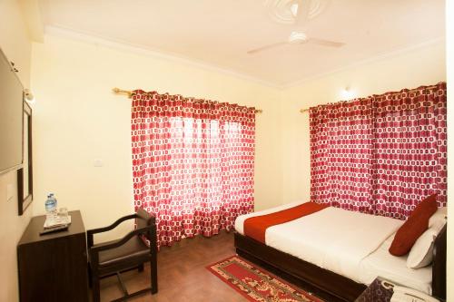 a bedroom with a bed and a red curtain at Hotel The Holy Birth in Lumbini