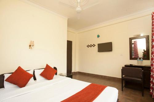 a bedroom with a bed and a tv on the wall at Hotel The Holy Birth in Lumbini