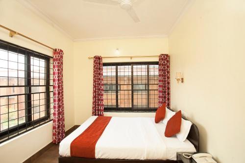 a bedroom with a bed and two windows at Hotel The Holy Birth in Lumbini