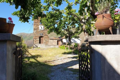 an old house with a fence and a plant at Casa do Loureiro in Arganil