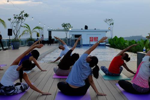 a group of people doing yoga by a pool at INNSiDE by Meliá Yogyakarta in Yogyakarta