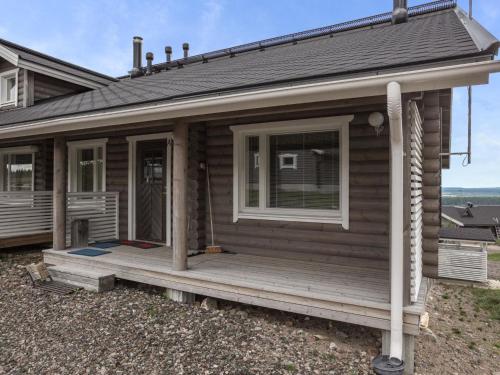 uma pequena casa de madeira com um alpendre e uma janela em Holiday Home Ylläksen rinnemäki a by Interhome em Ylläs