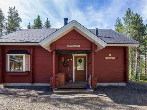 czerwony dom z gankiem i drzwiami w obiekcie Holiday Home Lemmenlaakso by Interhome w mieście Äkäslompolo